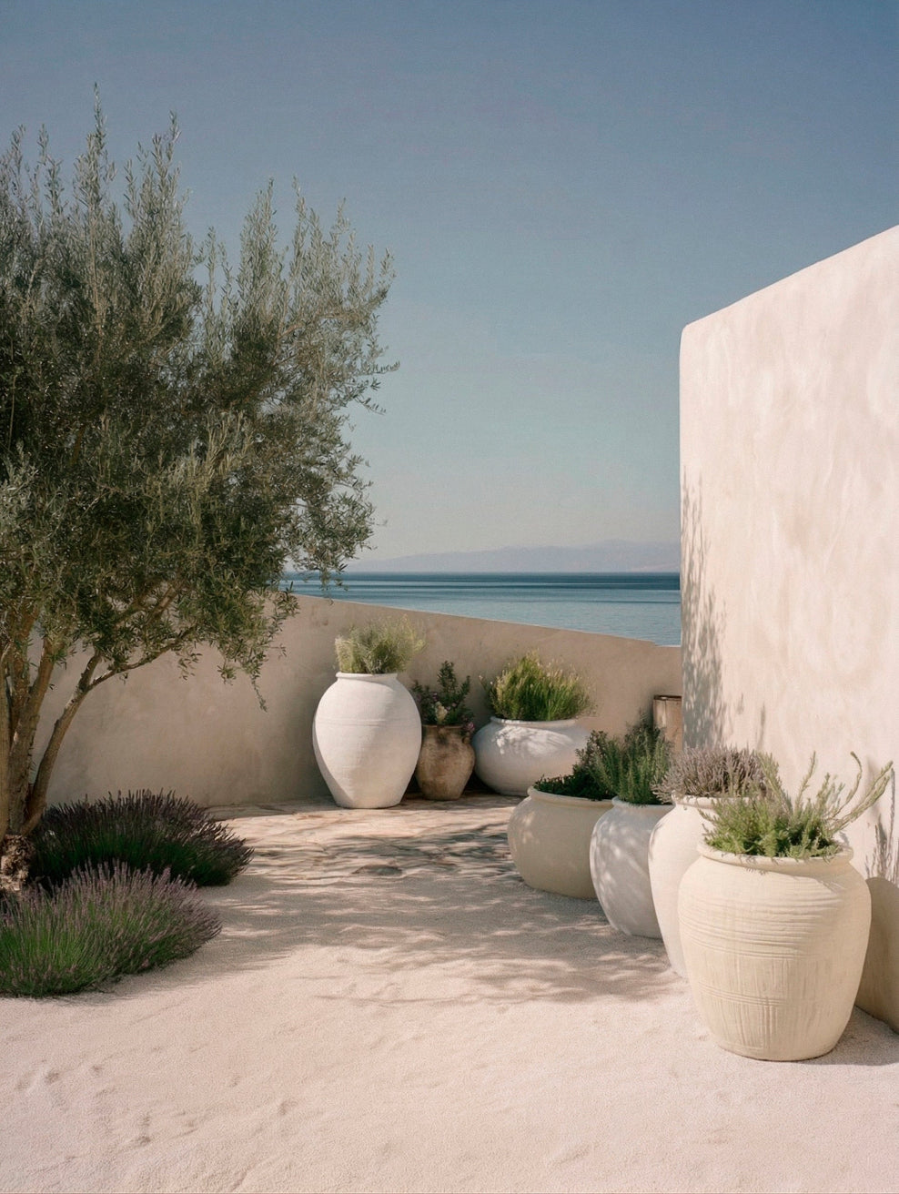 Coastal courtyard with limewashed garden planters in soft white and warm neutral tones, showing subtle colour variation across the Coastal Garden collection. | © Bauwerk Imagined, Christoph Neumann